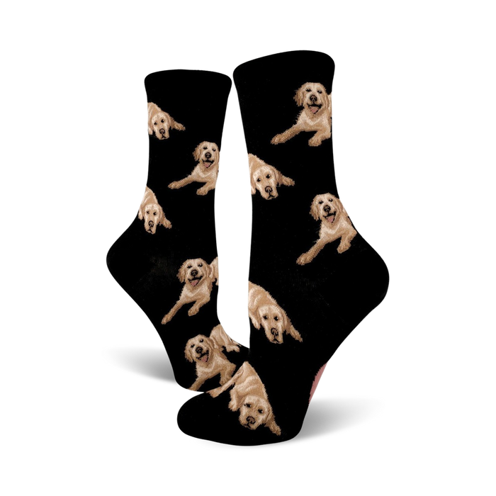 Pair of black crew socks covered in images of golden retrievers. The dogs are light tan and the background is black. }}