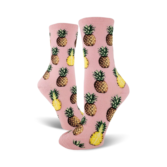 Pair of crew socks; pink and yellow pineapples on a pink background. Fun pineapple print socks.
