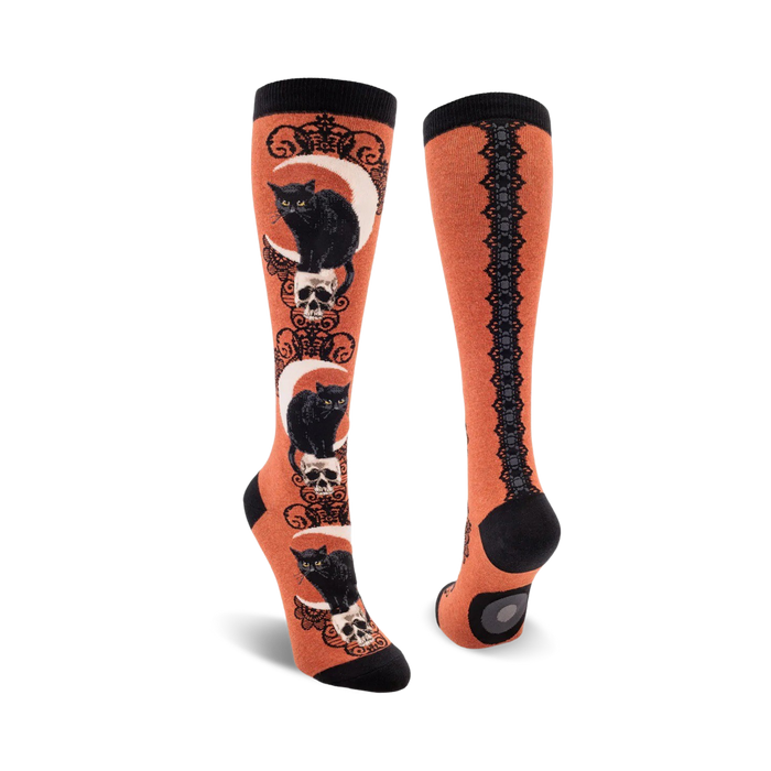 orange knee high socks with black cats, skulls and crescent moons and a lace pattern.  