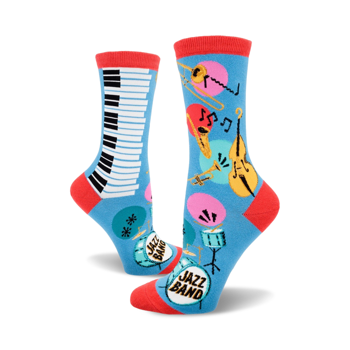 A pair of blue crew socks with a jazz band theme. One sock shows a piano keyboard, the other features musical instruments like a trombone, trumpet, and double bass. }}