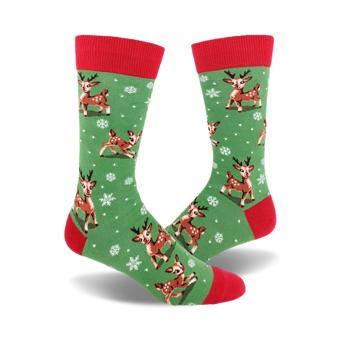 A pair of crew socks with a green background, red cuffs, and a pattern of brown reindeer and white snowflakes. }}
