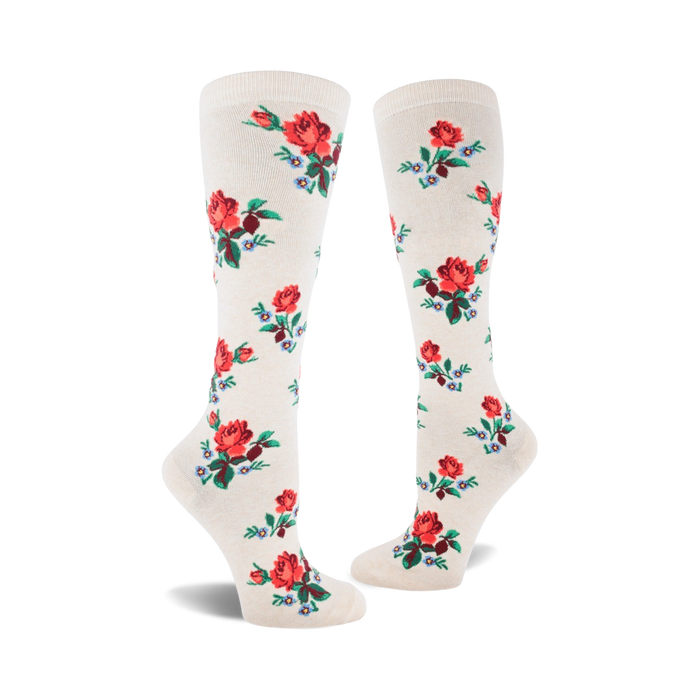 Pair of cream-colored knee-high socks adorned with a repeating pattern of red roses and small blue flowers. }}