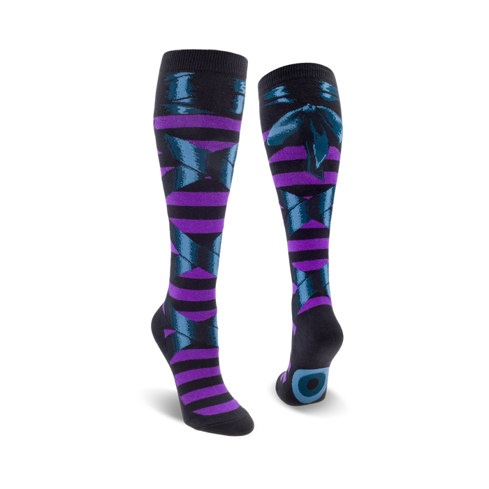 A pair of knee-high socks in purple and teal. The socks feature a striped pattern and a dark teal bow design. }}