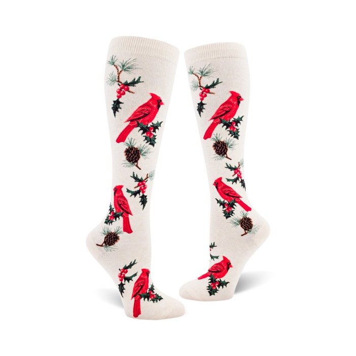 Pair of cream-colored knee-high socks with a repeating pattern of red cardinals, holly berries, and pine cones. }}