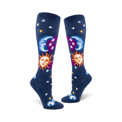 Pair of navy blue knee-high socks with whimsical sun, moon, and stars design.  Features smiling sun and moon faces, purple accents, and white stars.