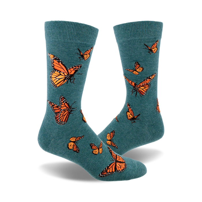 socks that are dark teal with an all-over pattern of monarch butterflies. the butterflies are orange, black, and white. }}