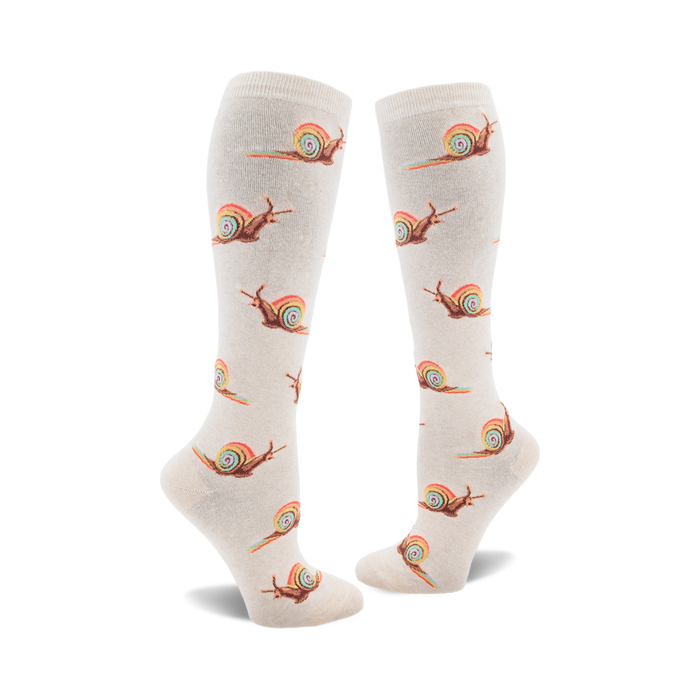Pair of cream-colored knee-high socks adorned with a repeating pattern of brown snails leaving rainbow trails. }}
