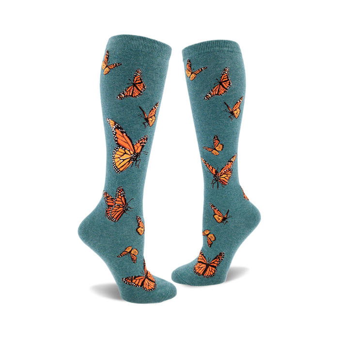 Pair of teal blue knee-high socks adorned with a pattern of orange monarch butterflies. Fun and stylish. }}