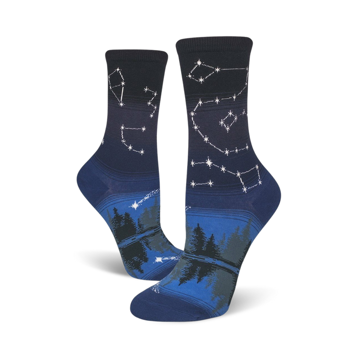 Pair of crew socks in navy blue and dark grey. Features a night sky design with constellations and a forest reflection. }}