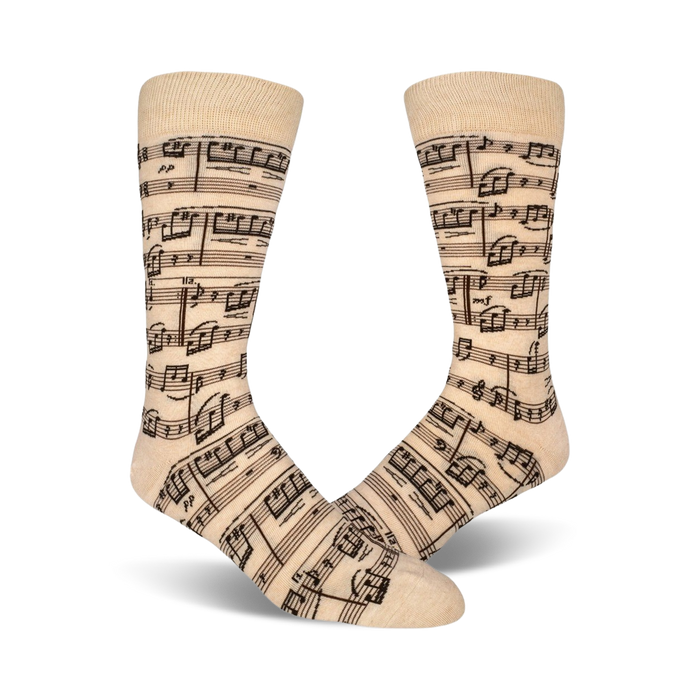 Close-up lifestyle shot of beige musical note socks on a person's feet.