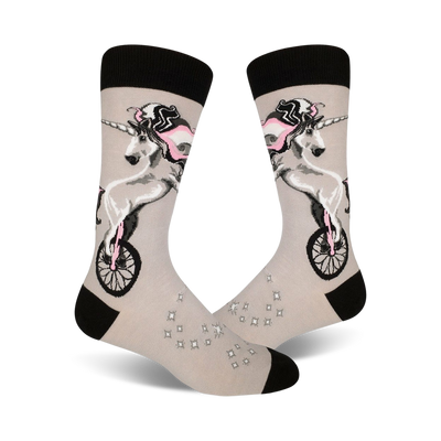 A pair of crew socks in grey with a whimsical design of a unicorn riding a unicycle, accented with pink and black details.