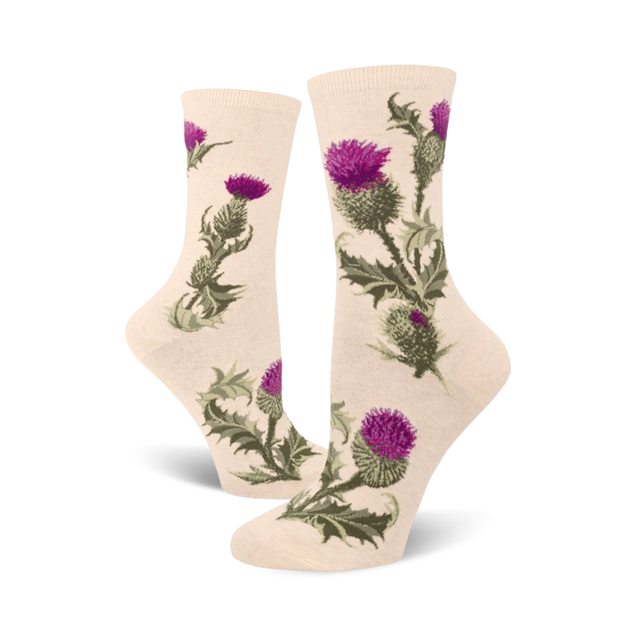 Cream crew socks adorned with a repeating pattern of purple and green thistles. Botanical illustration style.