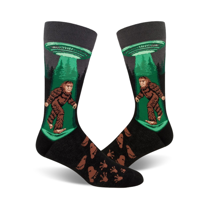 crew-length socks depicting sasquatch being beamed up by ufo, black background, with footprints.   }}