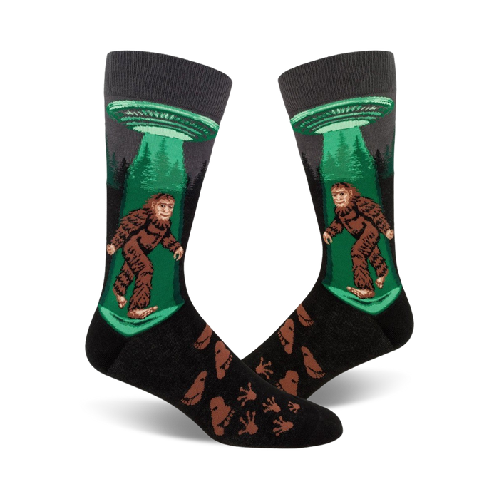 Crew socks in black, green, and brown featuring Bigfoot being beamed up by a UFO.  Footprints are printed on the lower part of the sock. }}