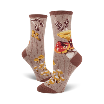 Pair of crew socks, featuring various types of mushrooms in red, brown, and yellow on a taupe background. A whimsical, nature-inspired design.