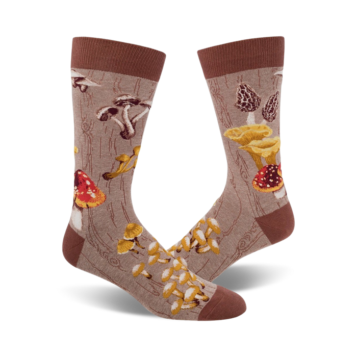 Pair of crew socks with a mushroom design.  The socks are beige/brown and green with various colorful mushroom illustrations on a wood-grain background.