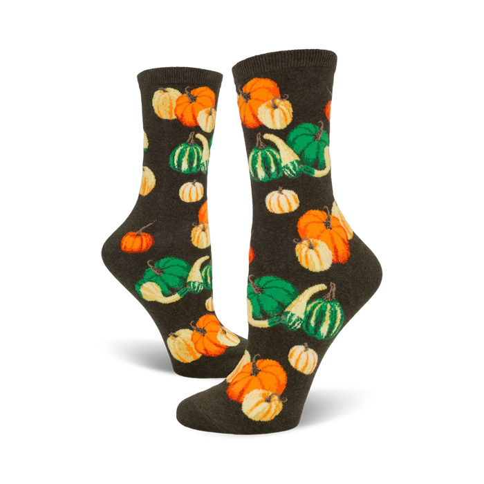 A pair of women's crew socks in dark green, adorned with a whimsical pattern of orange and green pumpkins and gourds. }}
