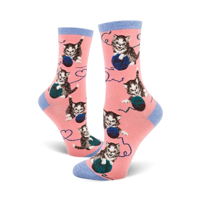 Crew socks in pink with a pattern of grey kittens playing with balls of yarn. Blue accents on the cuffs. }}