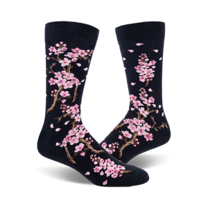 Close-up view of a pair of navy blue crew socks with a delicate pink cherry blossom pattern.