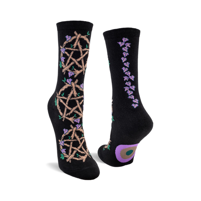 Black crew socks with a beige pentagram and purple flower design on one side and a line of purple flowers on the other. A small circle design is on the heel. }}