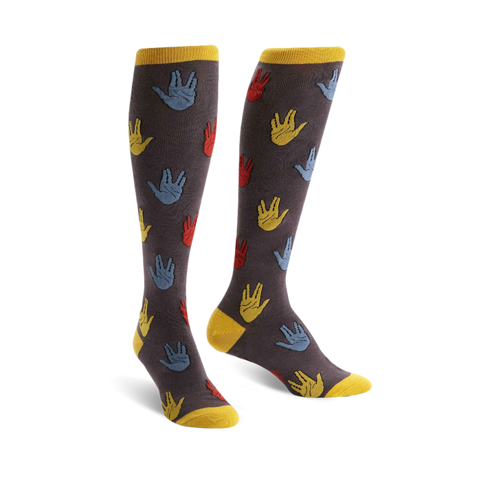 A pair of knee-high socks with a dark gray background and a repeating pattern of colorful Vulcan salutes in red, blue, and yellow. }}