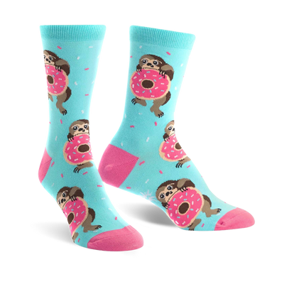 A pair of pastel blue crew socks features sloths hugging pink donuts and light blue sprinkles. The socks have pink heels and toes.