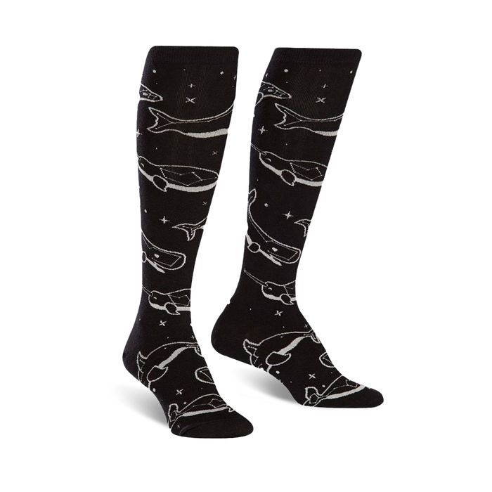 Pair of black knee-high socks with a repeating pattern of light grey whales and stars. The socks glow in the dark. }}