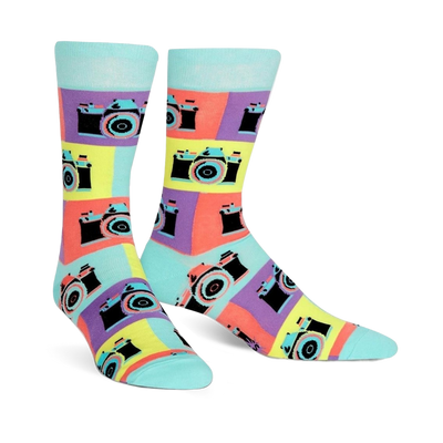 A pair of crew socks with a retro camera design. The socks are teal, purple, yellow, and orange, with black camera details.
