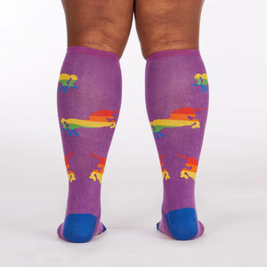 A pair of purple knee-high socks with a pattern of rainbow-colored unicorns.