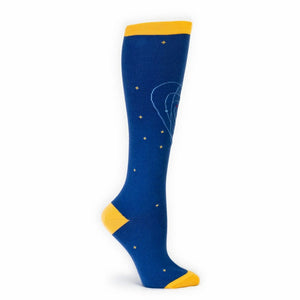 A blue knee-high sock with a yellow band at the top and yellow stars scattered throughout. There is an elephant in the center of the sock that is made up of red, white, and light blue.