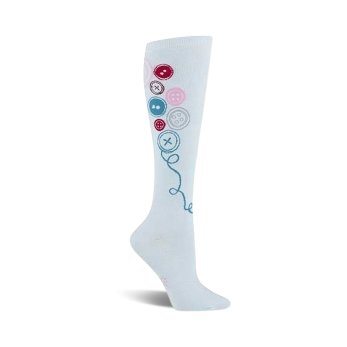 White knee-high socks adorned with colorful buttons in pink, red, and blue, connected by a teal thread design. }}