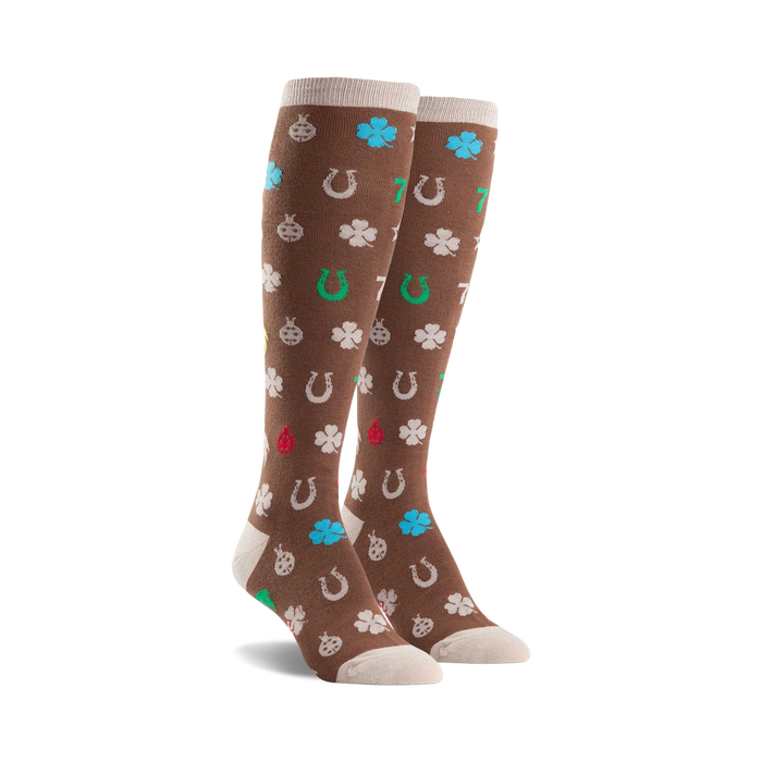 Pair of brown knee-high socks featuring a pattern of four-leaf clovers, horseshoes, ladybugs, and the number seven in various colors. }}