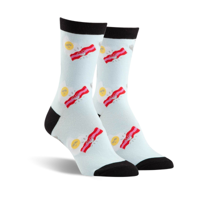 Pair of crew socks in light blue with a fun design of fried eggs and bacon strips. Black toe and heel.