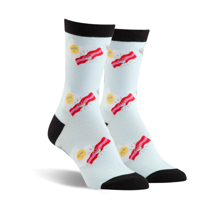 Pair of crew socks in light blue with a fun design of fried eggs and bacon strips. Black toe and heel. }}