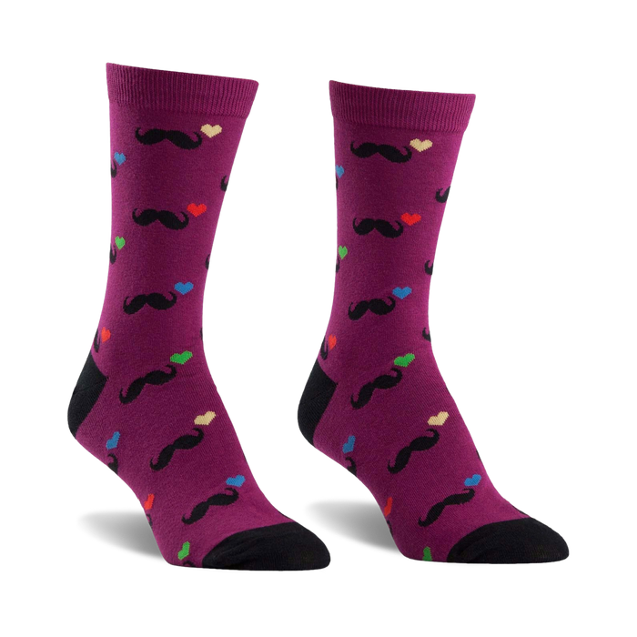 A pair of purple crew socks with a fun pattern. Black mustaches and multicolored hearts are playfully scattered across the socks, which have black heels and toes. }}