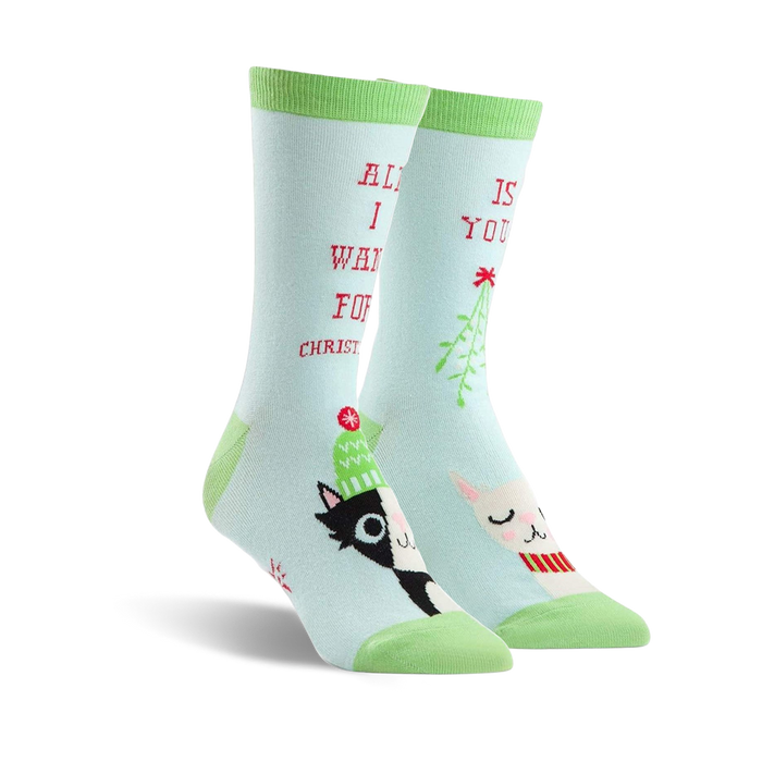 Pair of crew socks in teal green featuring a black and white cat, a llama wearing a scarf, mistletoe, and the text 'All I want for Christmas is you!'