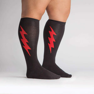 A pair of black knee-high socks with a red lightning bolt pattern.