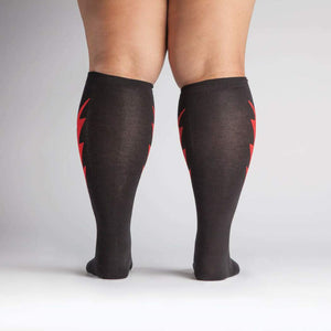 Rear view of a person wearing the black knee-high socks with red lightning bolts.