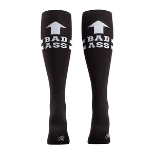 Rear view of a pair of black 'Bad Ass' knee-high socks on a person's legs.
