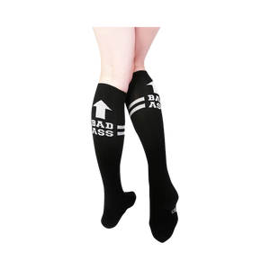 Pair of black knee-high socks with white stripes and 'Bad Ass' text.  Features an upward-pointing arrow graphic.
