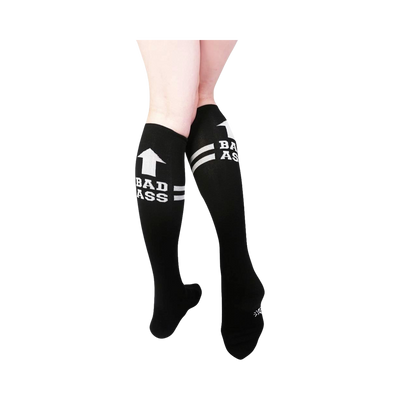 Pair of black knee-high socks with white stripes and 'Bad Ass' text. Features an upward-pointing arrow graphic.