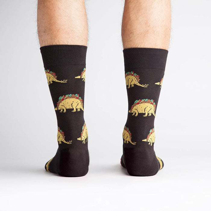 Back view of a person wearing Tacosaurus socks.  The image shows the complete sock design and a hint of the sock's cuff.