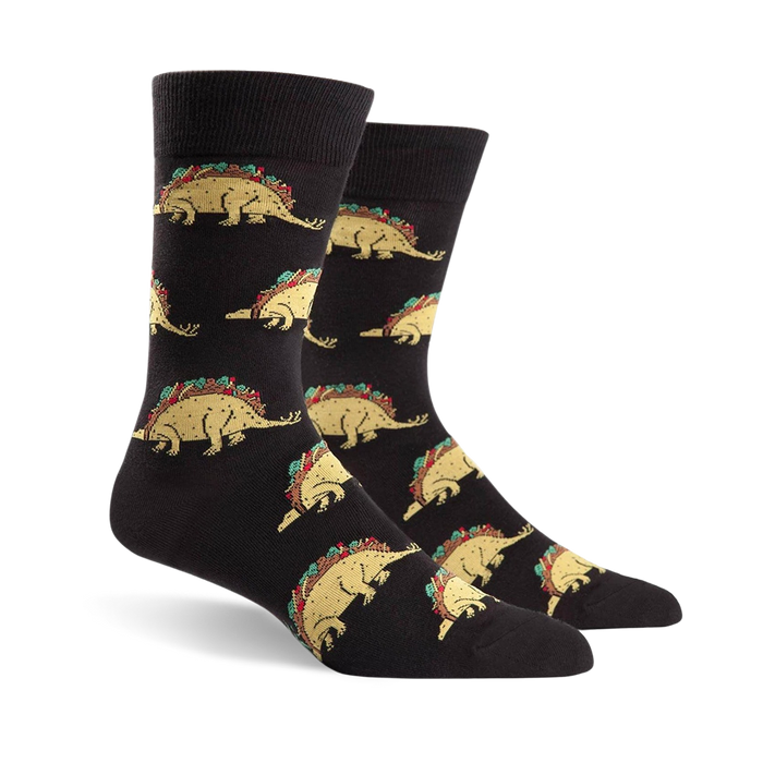Pair of black crew socks featuring a repeating pattern of tacosaurus illustrations. The tacosaurus is a dinosaur-shaped taco with all the fixings.