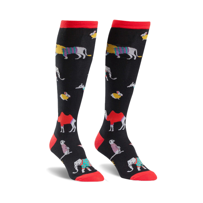 Pair of black knee-high socks with colorful animal designs including camels, elephants, and other creatures. Red tops. }}