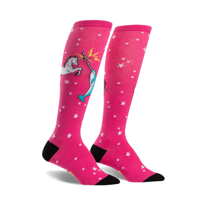 Pair of pink knee-high socks with white stars and a whimsical illustration of a unicorn fighting a narwhal. }}