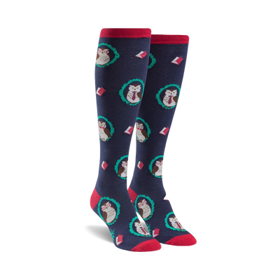 Pair of navy blue knee-high socks with a pattern of owls wearing glasses and surrounded by teal wreaths and books.