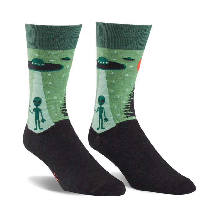Pair of crew socks in green and black. The design features grey aliens, UFOs, and a starry night scene. }}