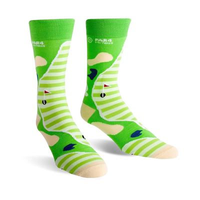 Pair of crew socks showing a golf course design. Green and cream stripes with sand traps, a flag, and golf ball.