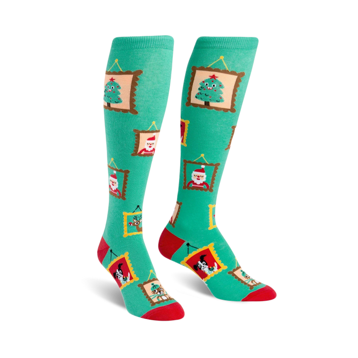 Pair of teal knee-high socks with red and gold accents. Festive designs in gold frames include a Christmas tree, Santa, reindeer and a dog. }}
