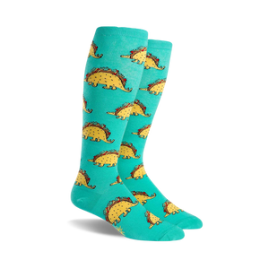 Pair of teal knee-high socks with a repeating pattern of cartoon dinosaurs shaped like tacos.